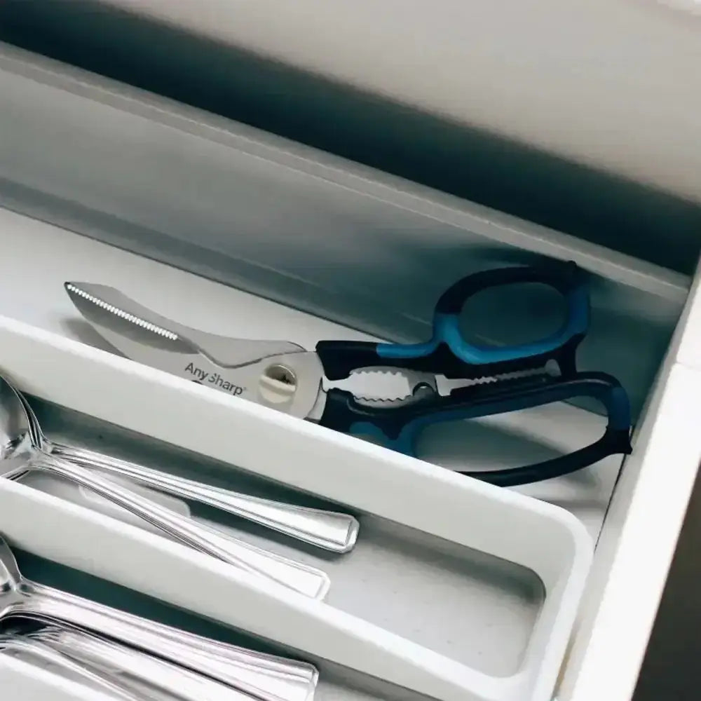 Set of kitchen utensils including scissors and knives in a drawer.