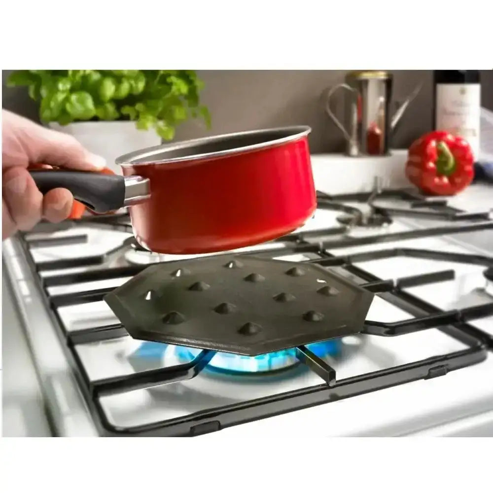 Red pot being held over a gas stove with a black heat diffuser
