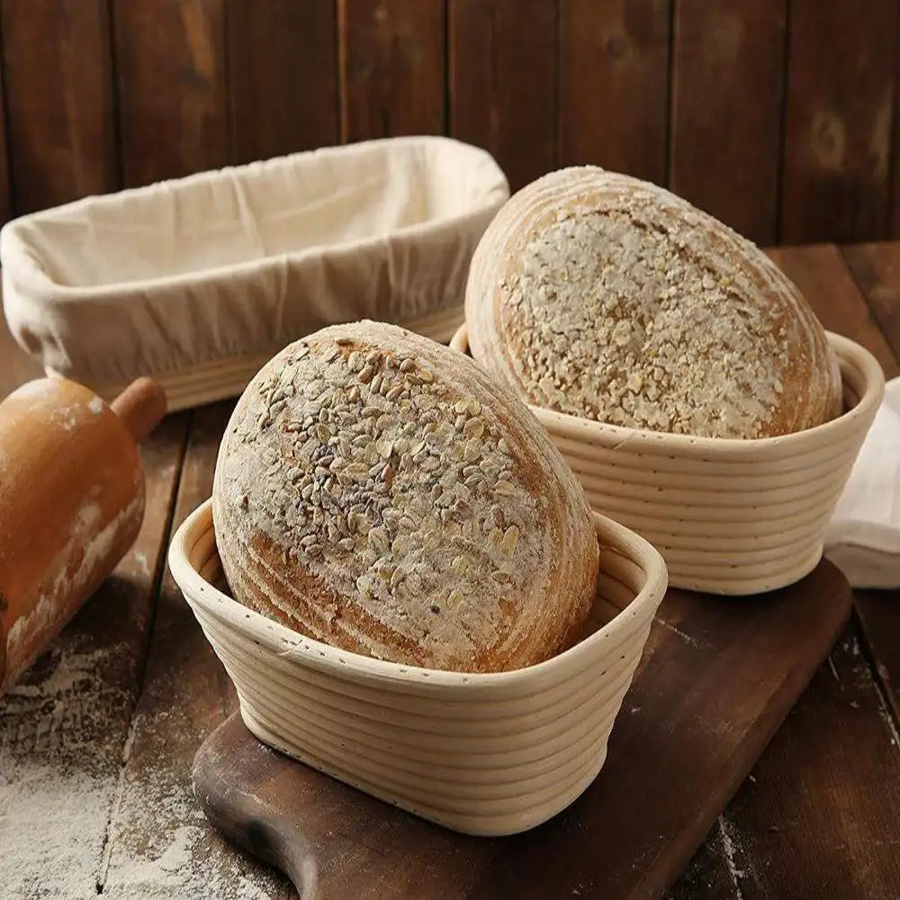 Two loaves of bread in woven baskets on a wooden surface with a rustic background.