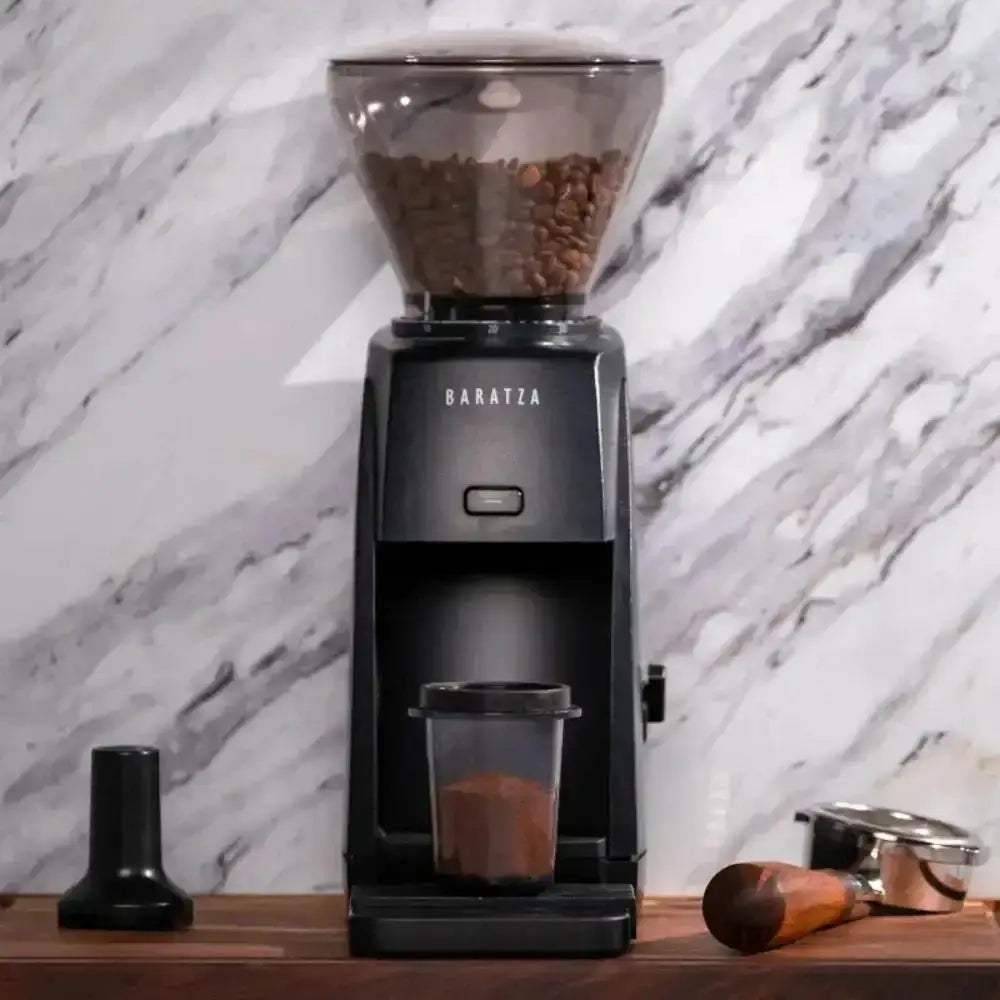 Baratza coffee grinder with coffee beans on a marble countertop
