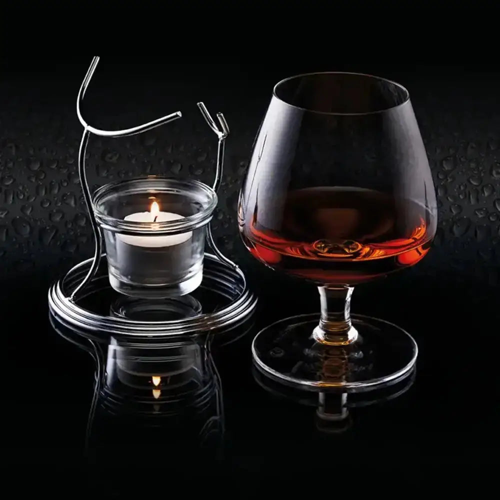 Cognac glass with a lit candle on a dark background