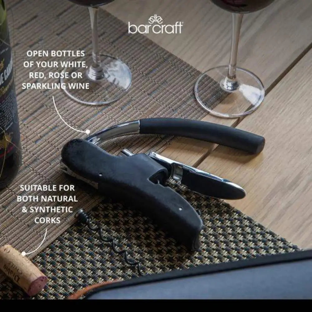 Wine opener on a table with wine bottles and glasses, featuring Barcraft branding.