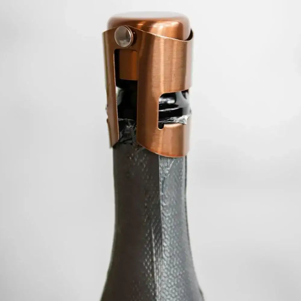 Bronze bottle opener on a wine bottle against a white background