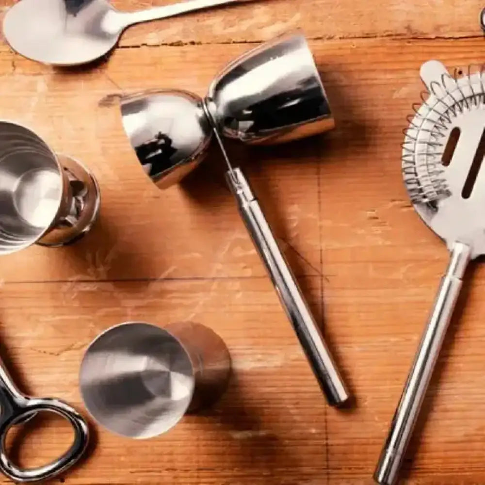 Set of cocktail-making tools on a wooden surface