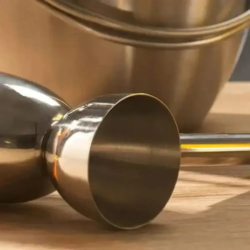 Stainless steel dual spirit measure cup on wooden surface, premium kitchenware at Cookin Stores.