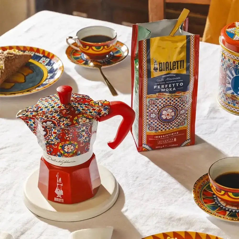Colorful Bialetti coffee maker with a box of Bialetti coffee on a table.
