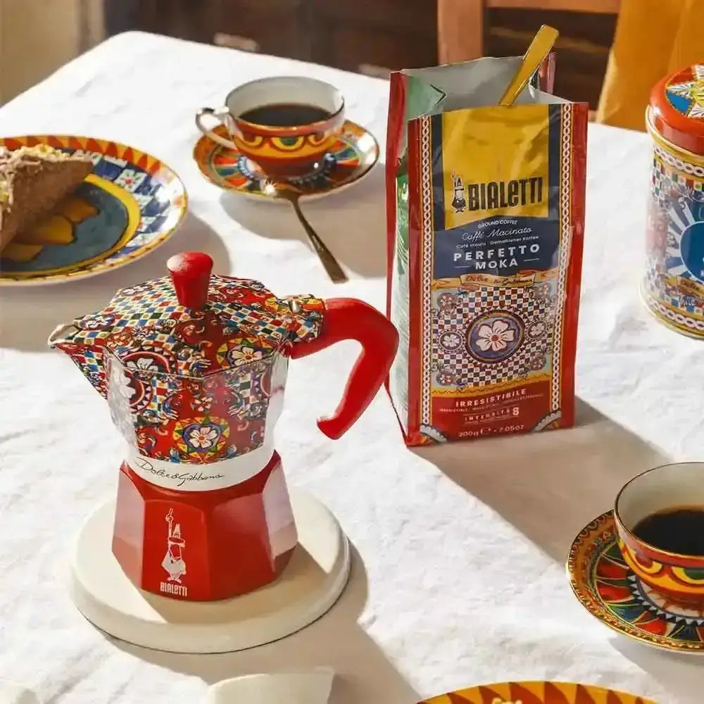 Colorful Bialetti coffee maker with a box of Bialetti coffee on a table.