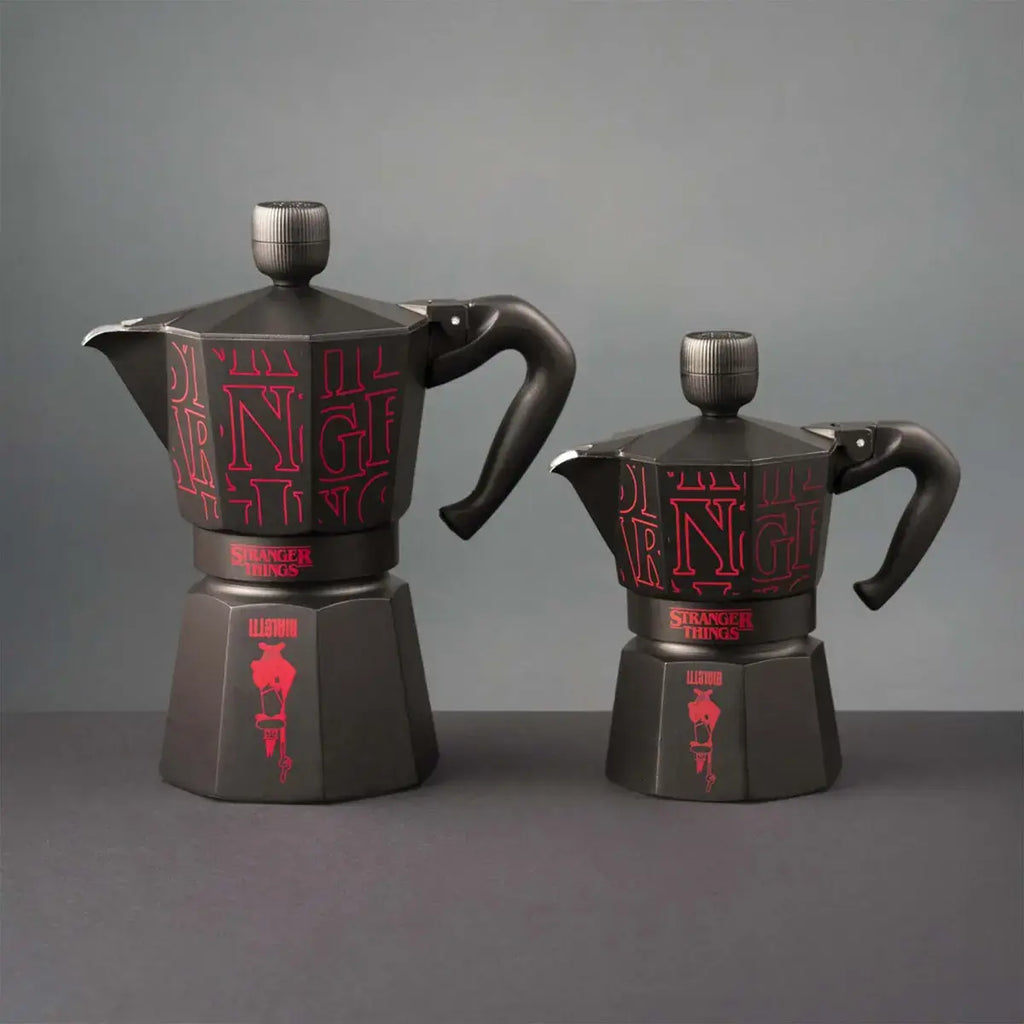 Two black coffee pots with red text on a gray background