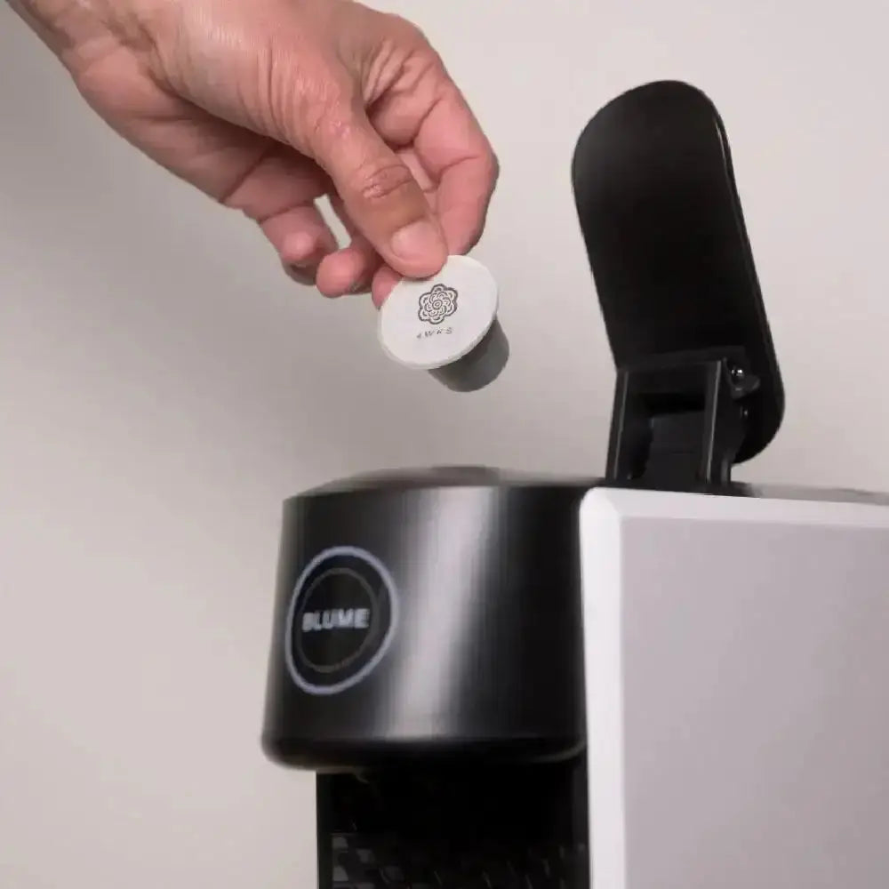 Blume 2-Step Pro Capsule Coffee Machine in white with a hand inserting a coffee pod, Cookin Stores premium kitchenware.