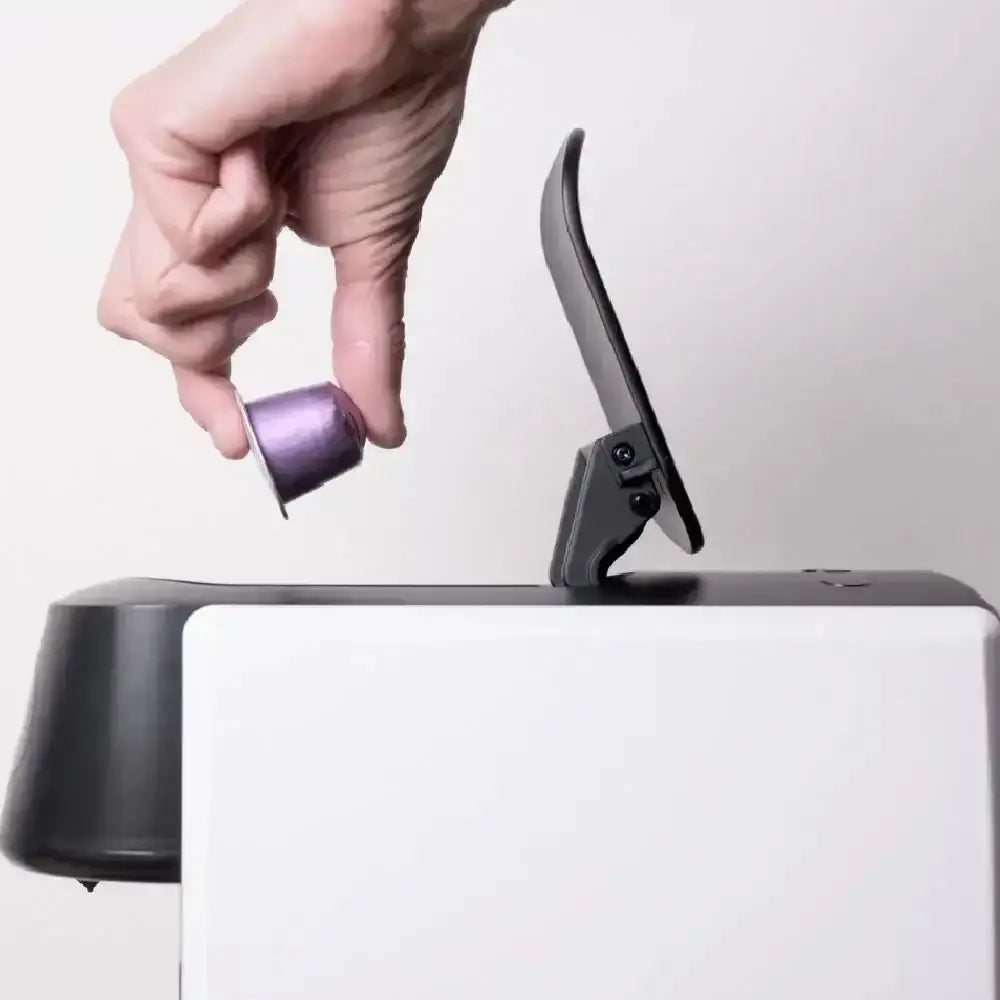 Hand placing capsule into Blume 2-Step Pro Capsule Coffee Machine in white from Cookin Stores