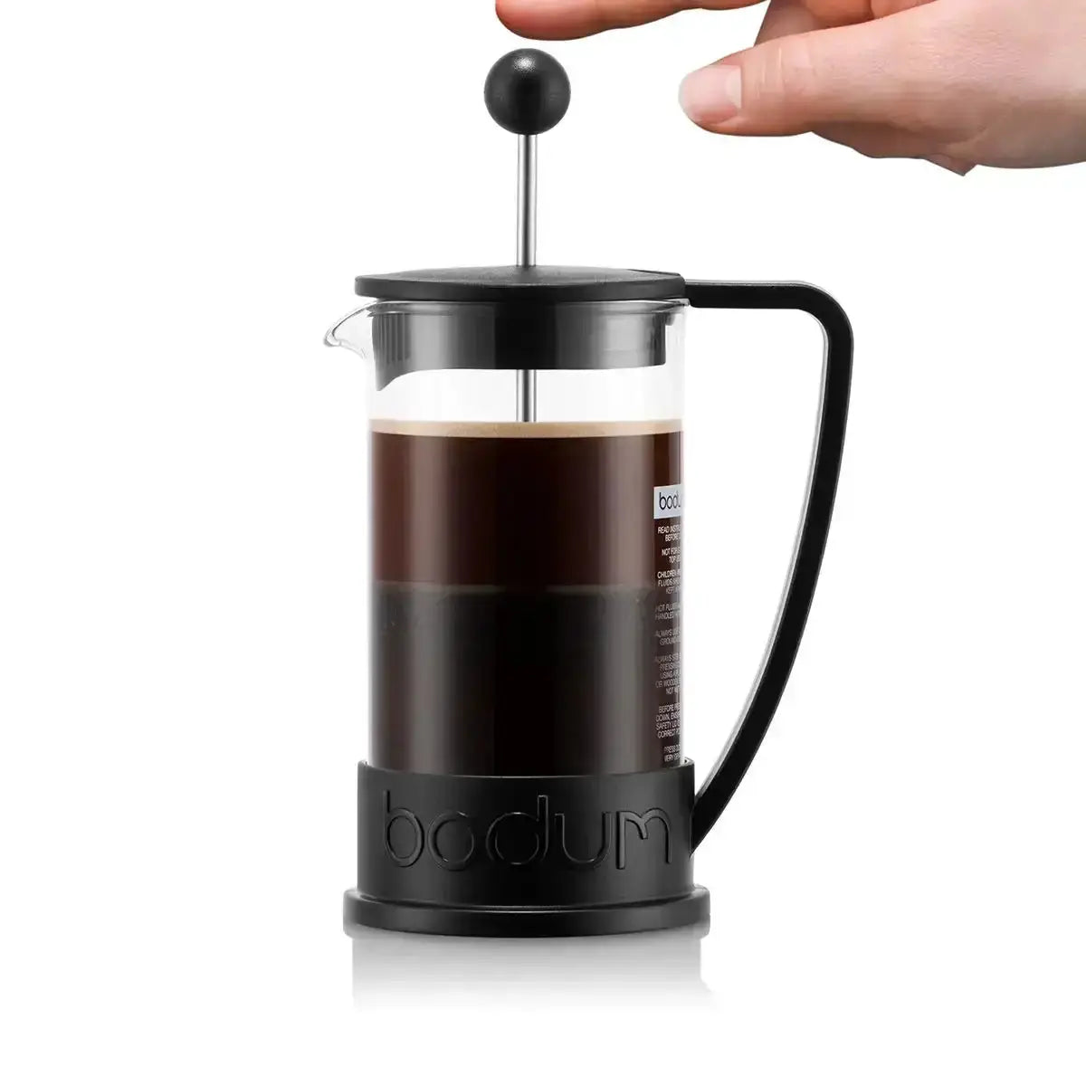 Bodum French press with coffee being pressed, on a white background