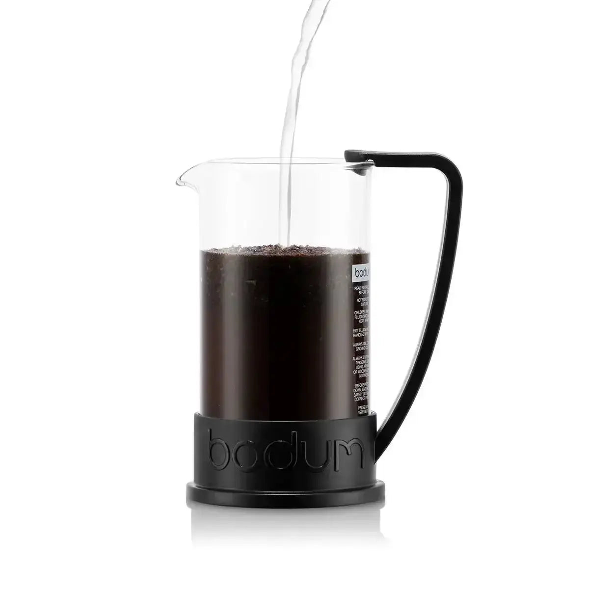 Bodum coffee maker with coffee being poured into it on a white background