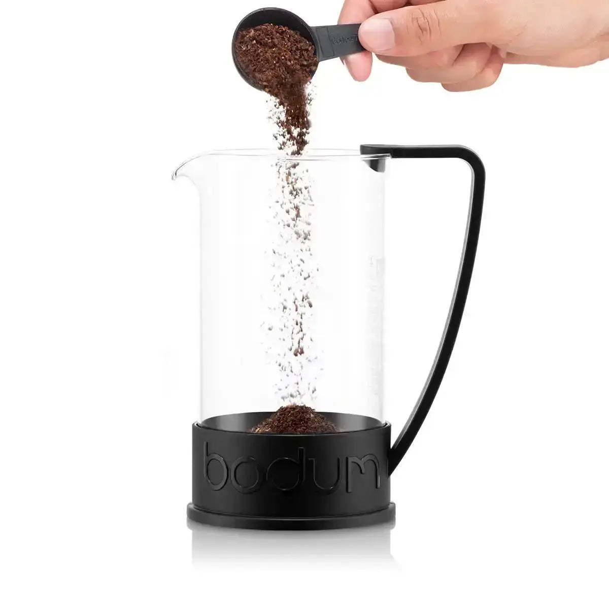 Bodum coffee maker with coffee being poured into it on a white background