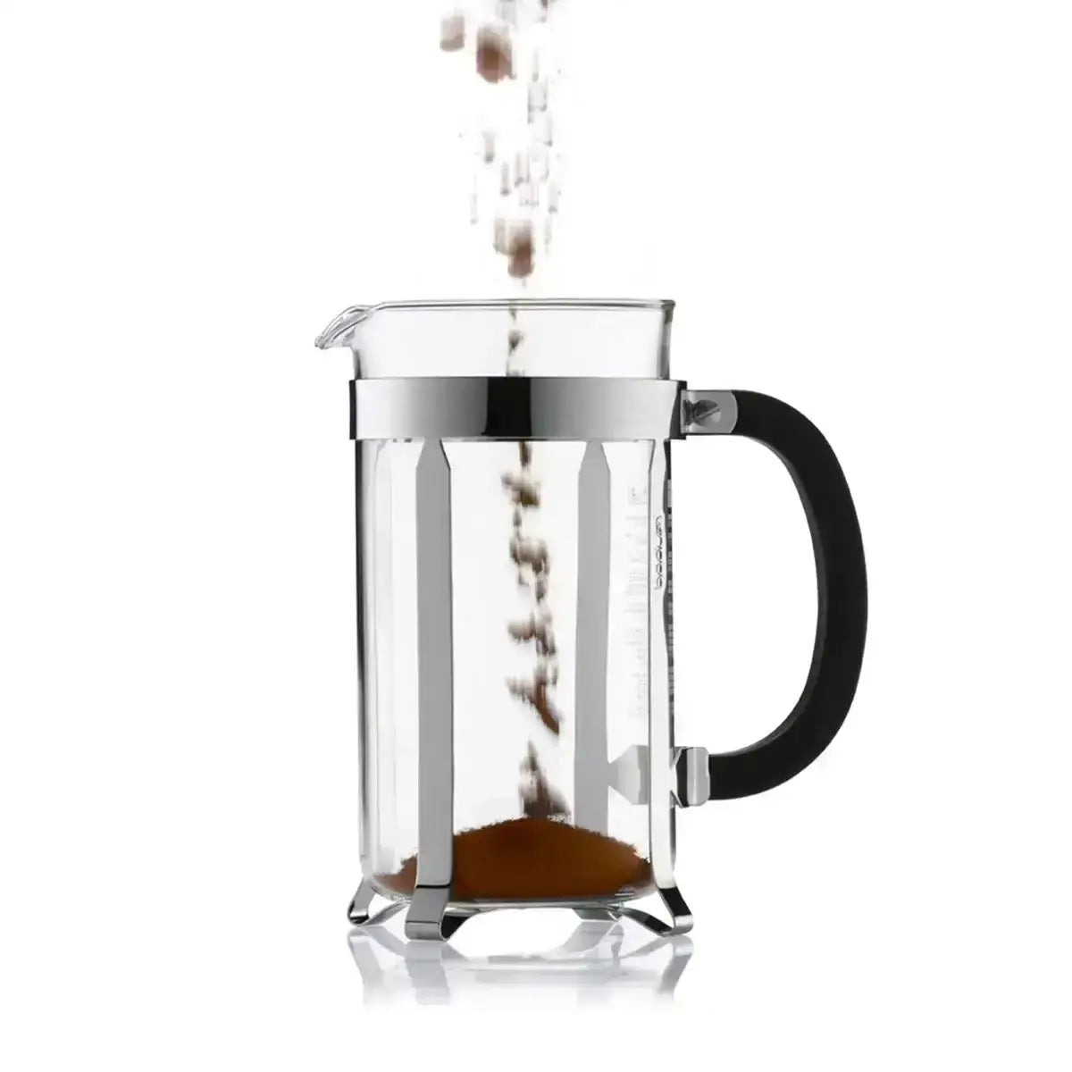French press with coffee being poured into it on a white background