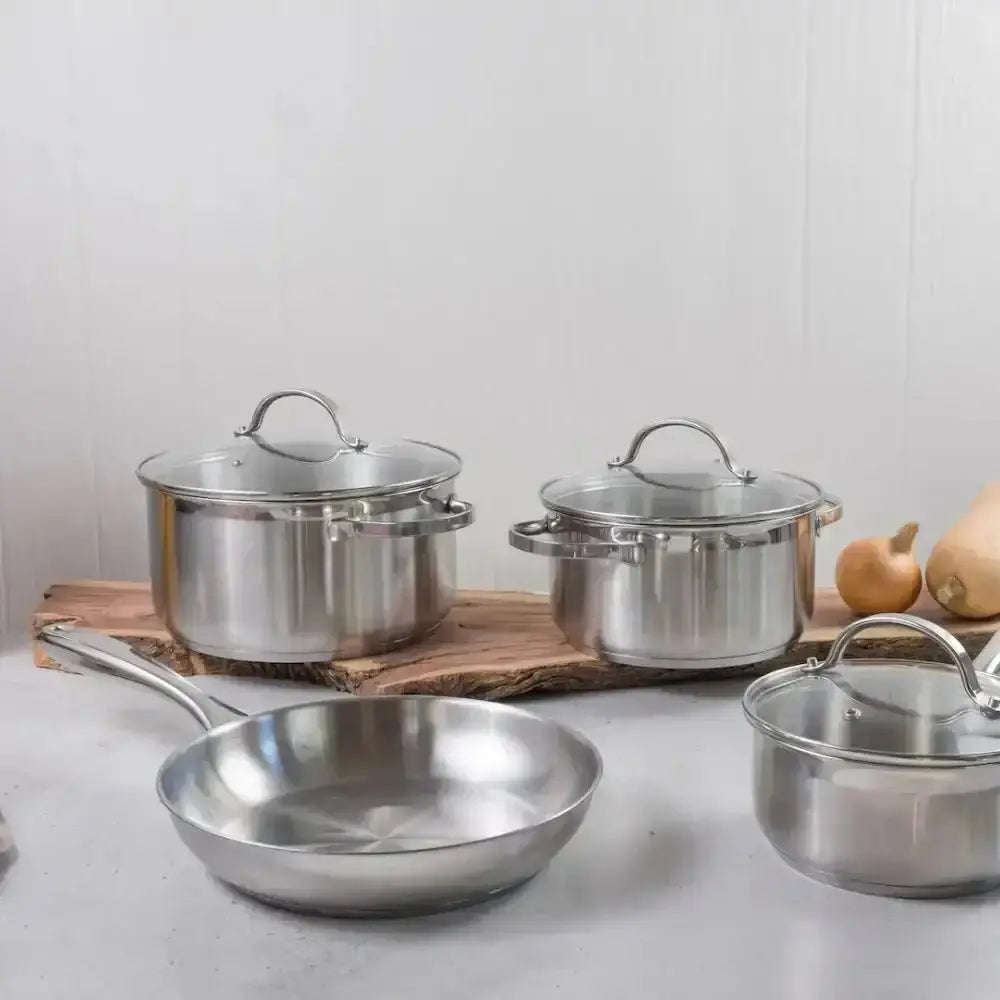 Set of stainless steel cookware on a kitchen counter with a neutral background
