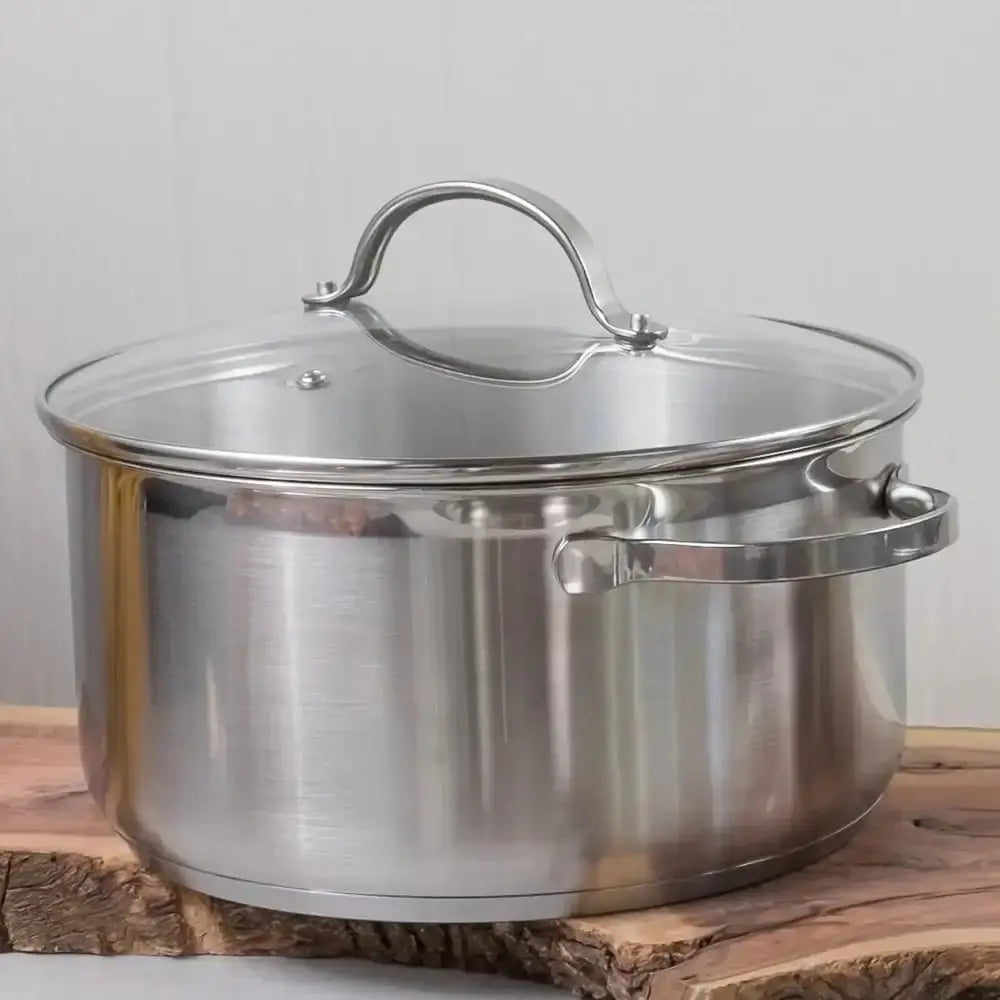 Stainless steel pot with lid on a wooden surface