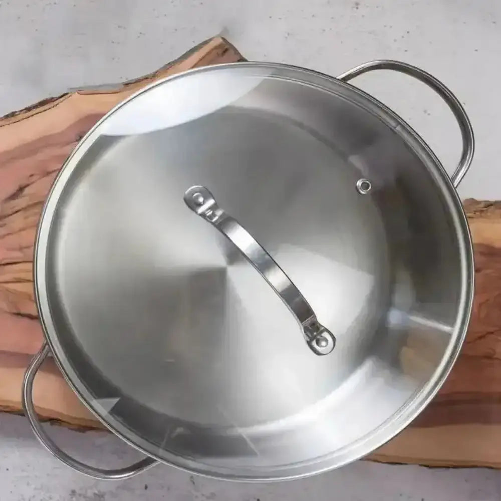Stainless steel pot with lid on a wooden surface