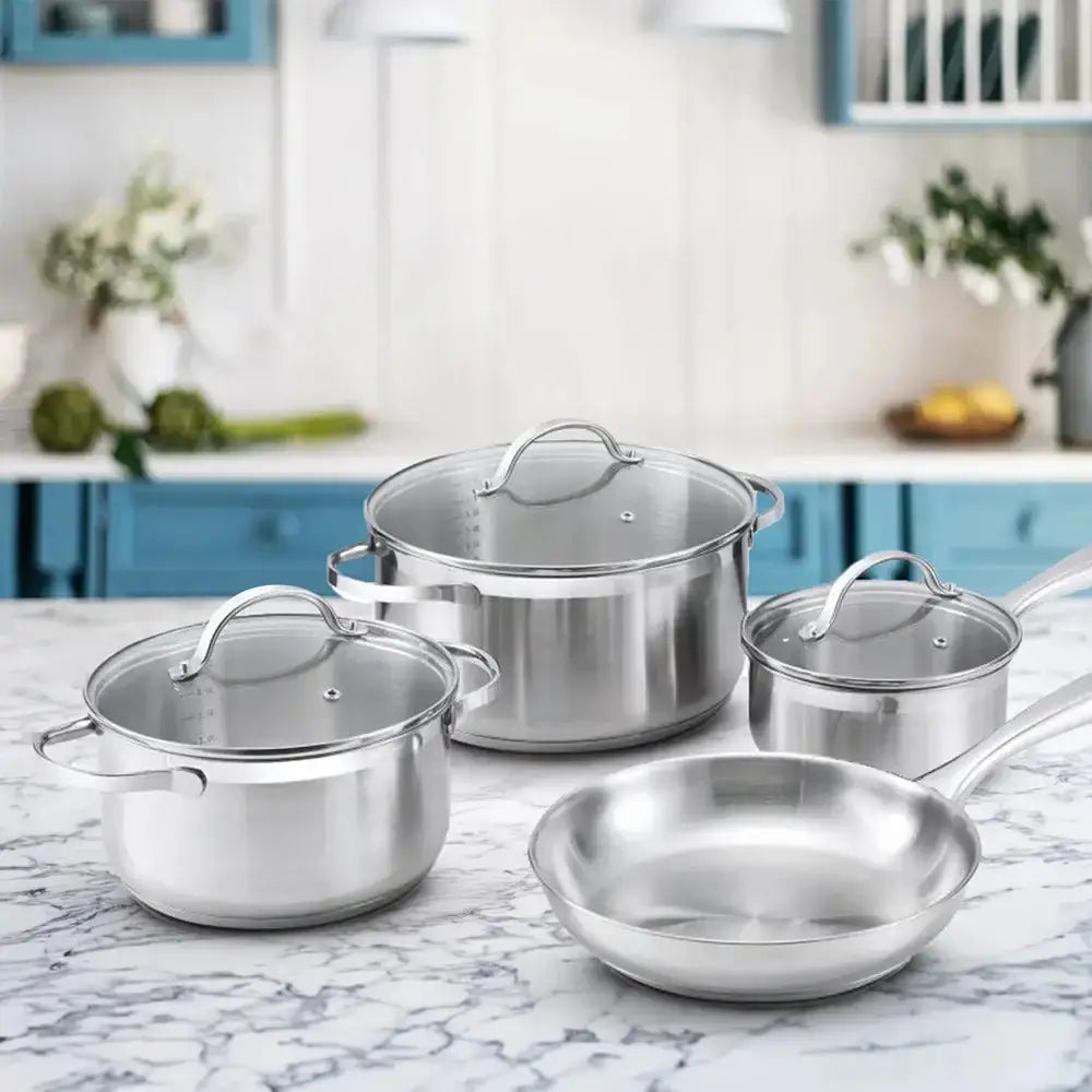 Set of stainless steel cookware on a marble countertop with a kitchen background.