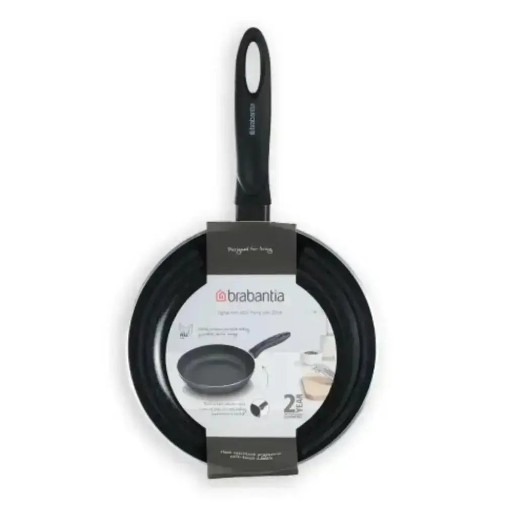 Black frying pan with handle and packaging on a white background