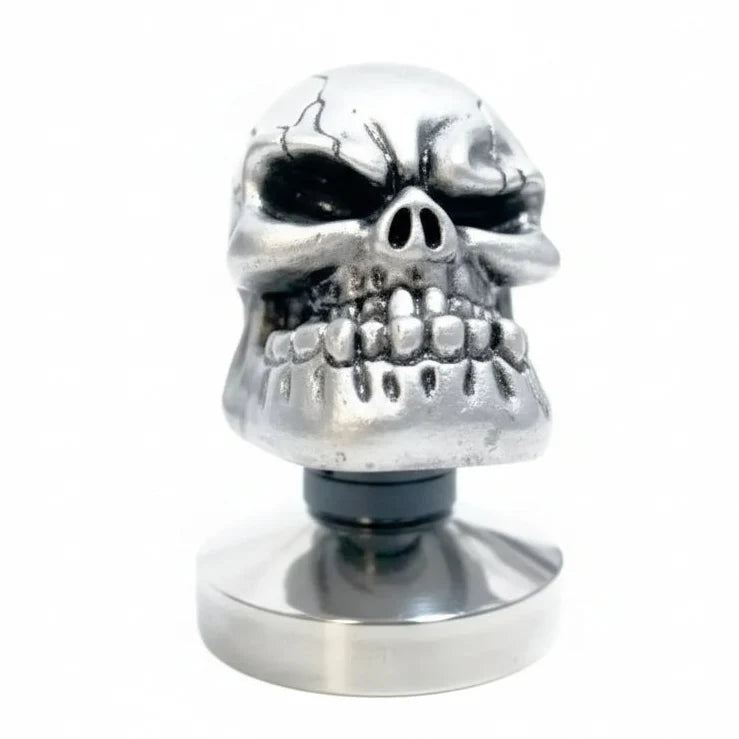 Metallic skull-shaped tamper on a white background