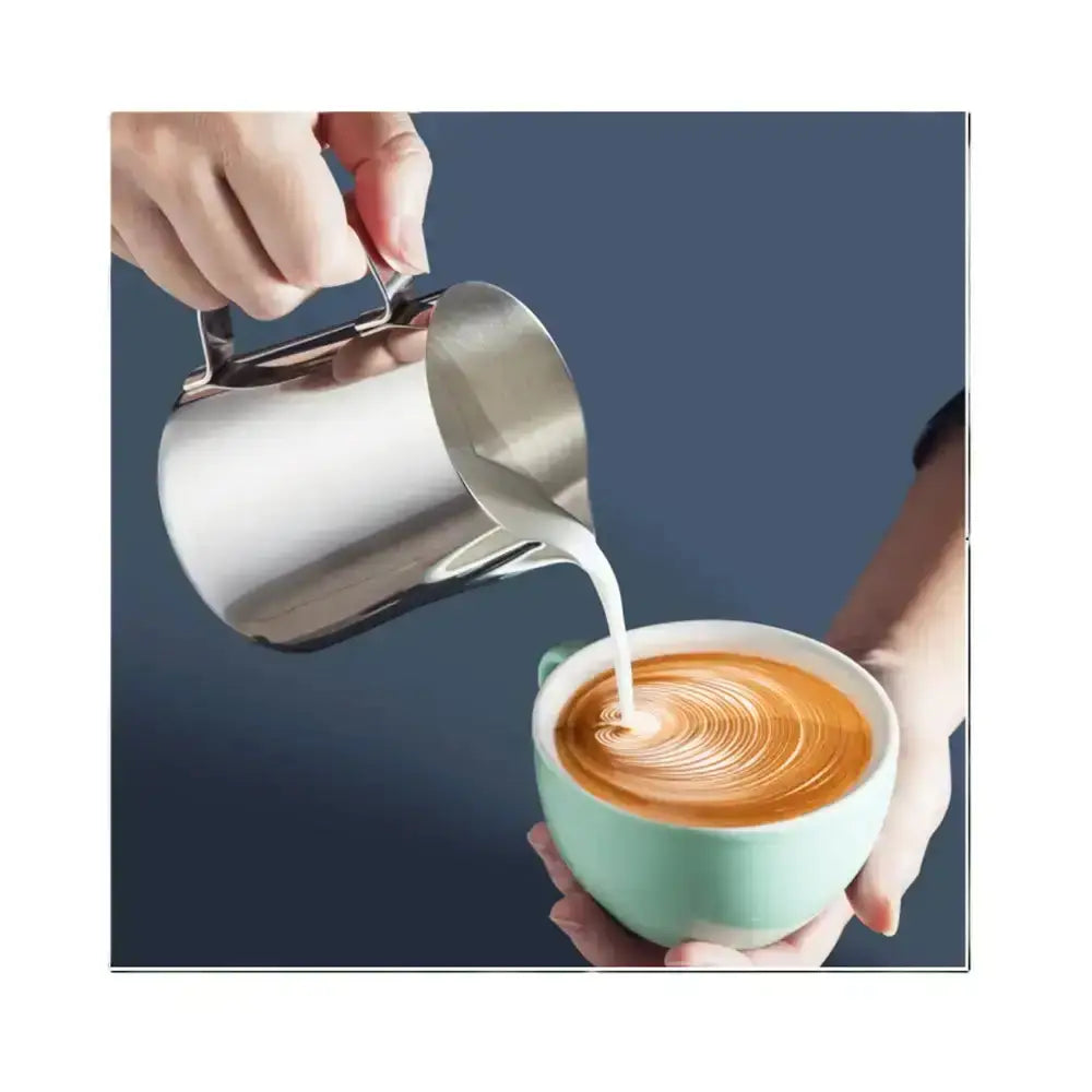Person pouring milk from a stainless steel pitcher into a cup of coffee with a blue background