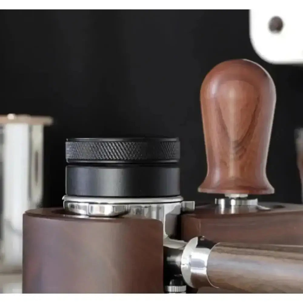 Close-up of a coffee tamp and other brewing equipment on a dark background