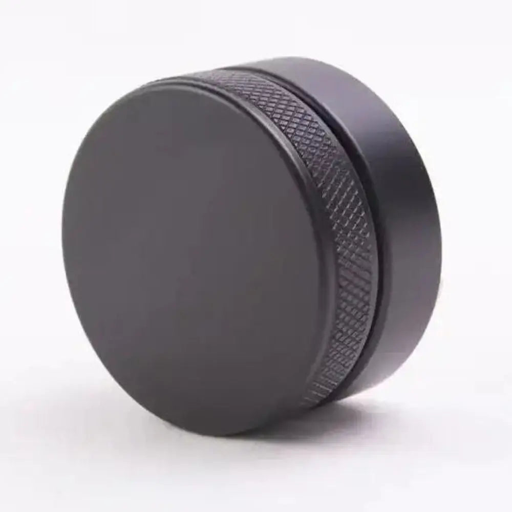 Black circular object with textured surface on a white background