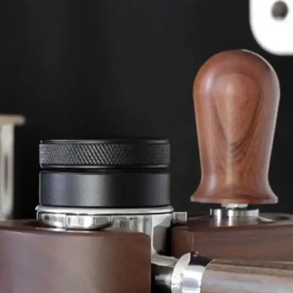 Close-up of coffee tampers with wooden and metal handles on a dark background