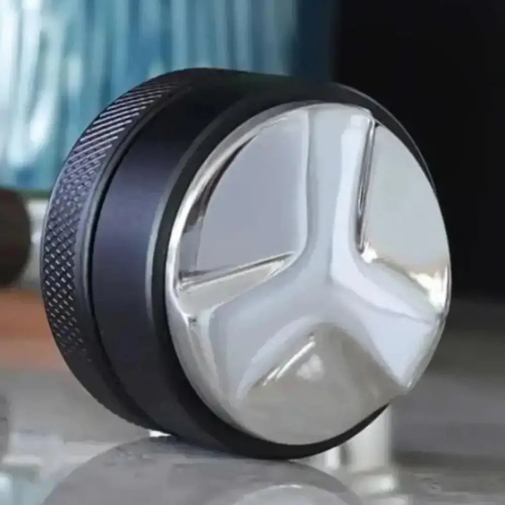 Close-up of a metallic wheel with a star design on a reflective surface