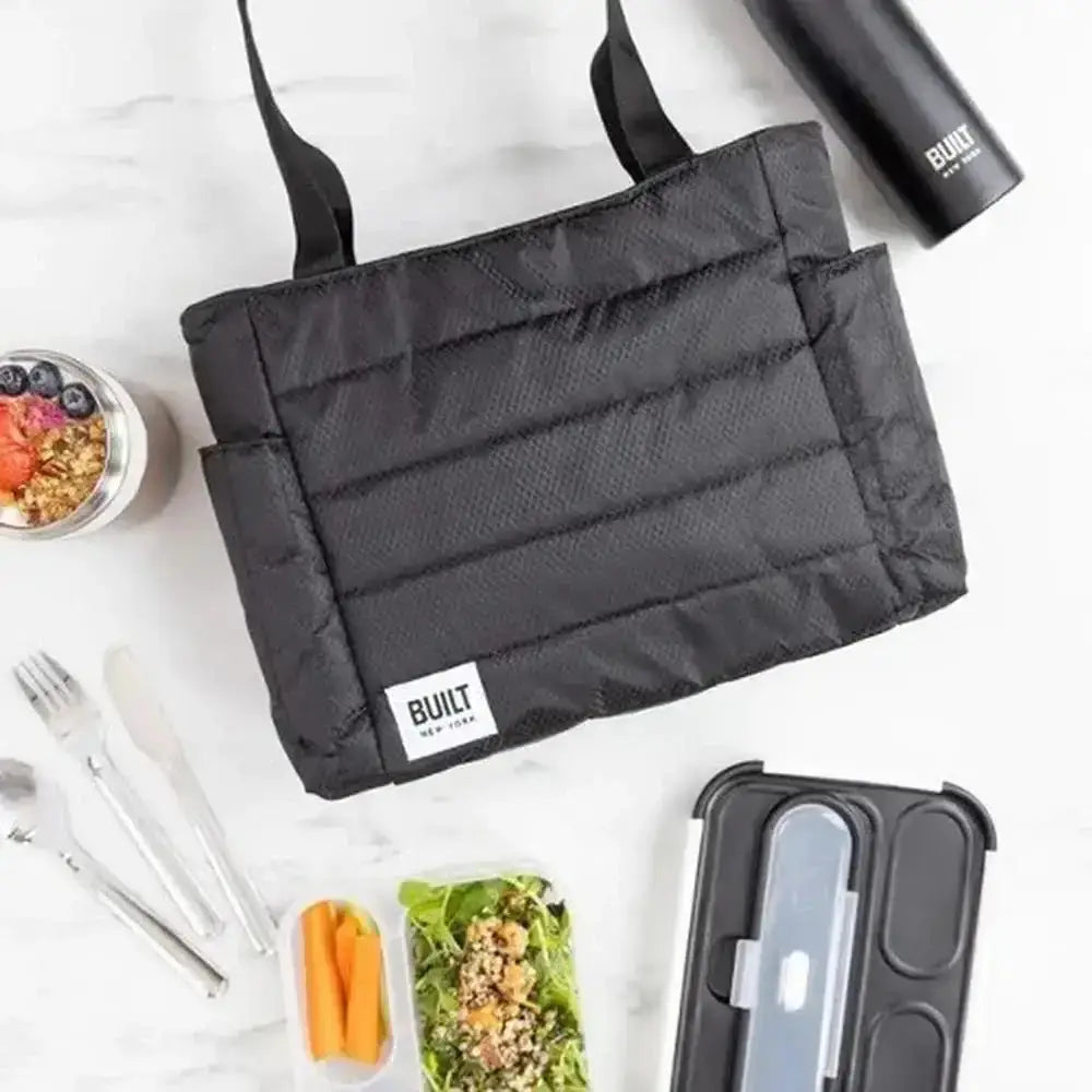 Black insulated lunch bag with a Built logo, surrounded by food containers and utensils on a white background.