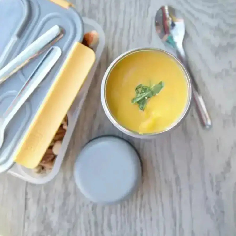 Yellow bowl with a spoon on a marble surface