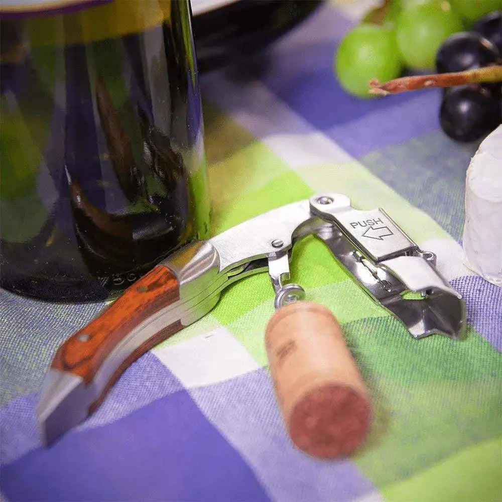 Cilio waiter's friend corkscrew with wood handle beside wine bottle and grapes on table at Cookin Stores
