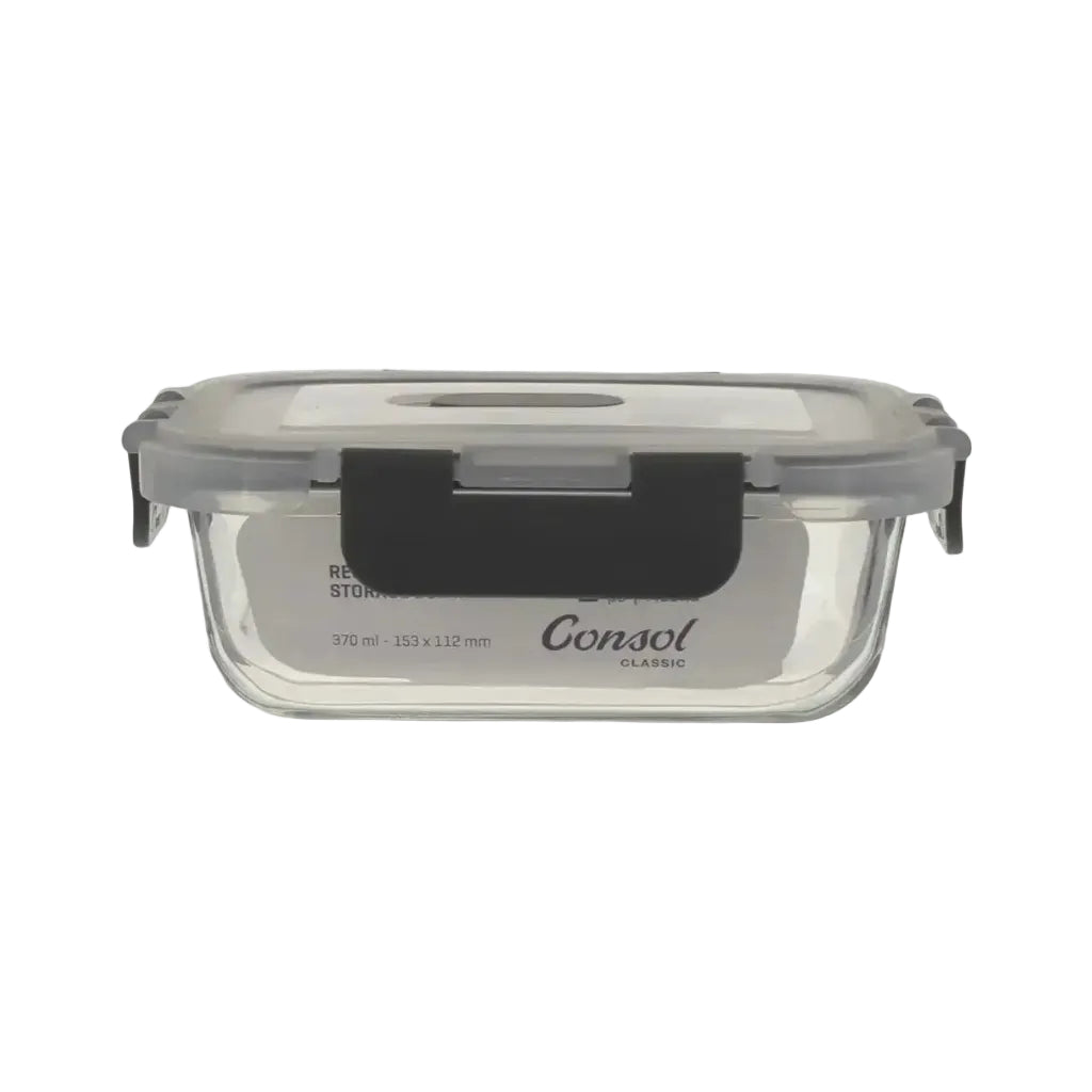 Clear glass food storage container with black lid on a white background