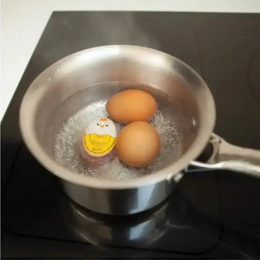 Two eggs boiling in a pot on a stove