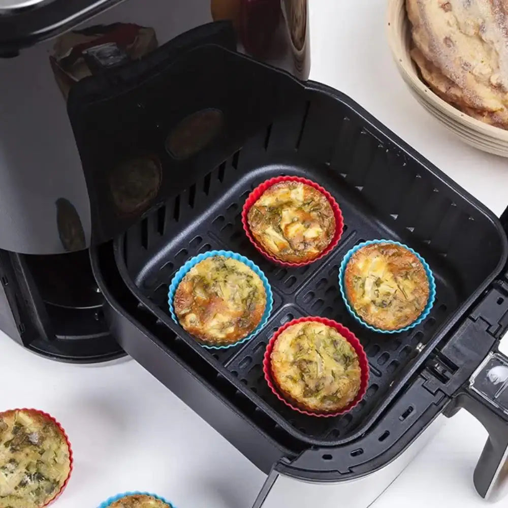 Air fryer with muffin tins containing baked goods on a white surface