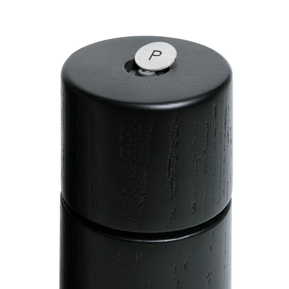 Black pepper grinder with a silver top on a white background