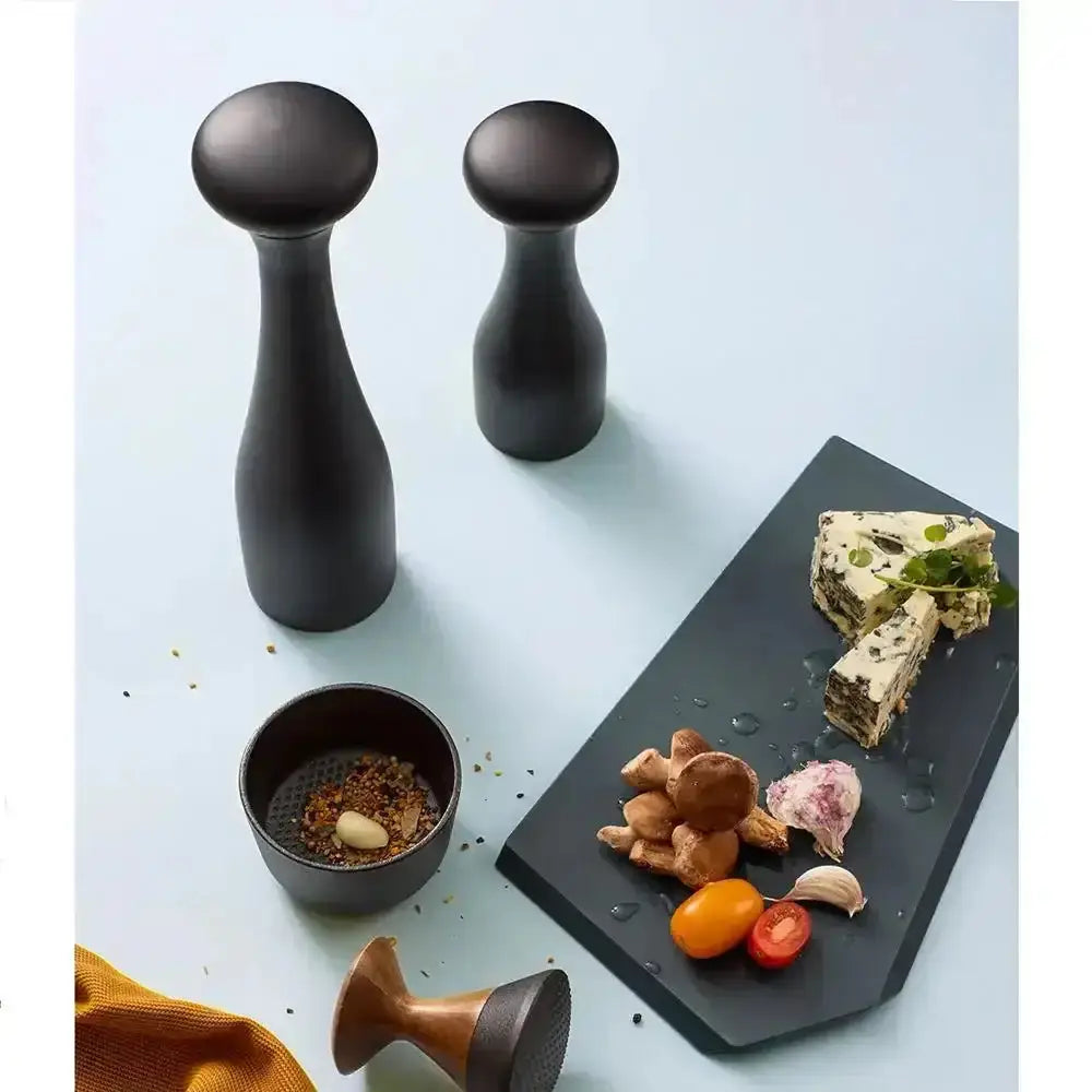 Black CrushGrind Lyon salt and pepper grinders on table with gourmet cheese and vegetables, Cookin Stores