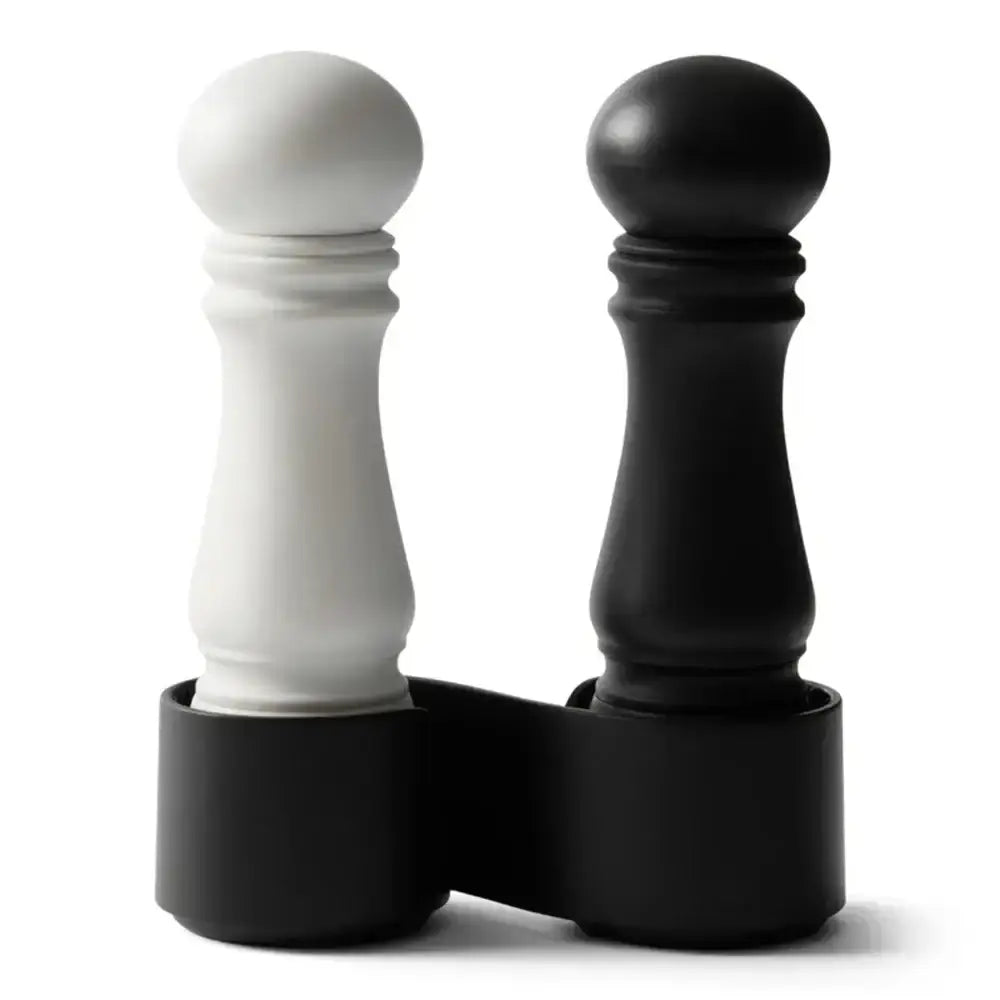 Black and white pepper grinders in a matching holder on a white background