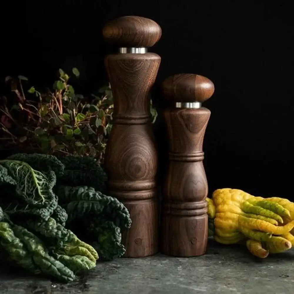 CrushGrind Paris walnut salt and pepper grinders on kitchen counter with leafy greens, Cookin Stores