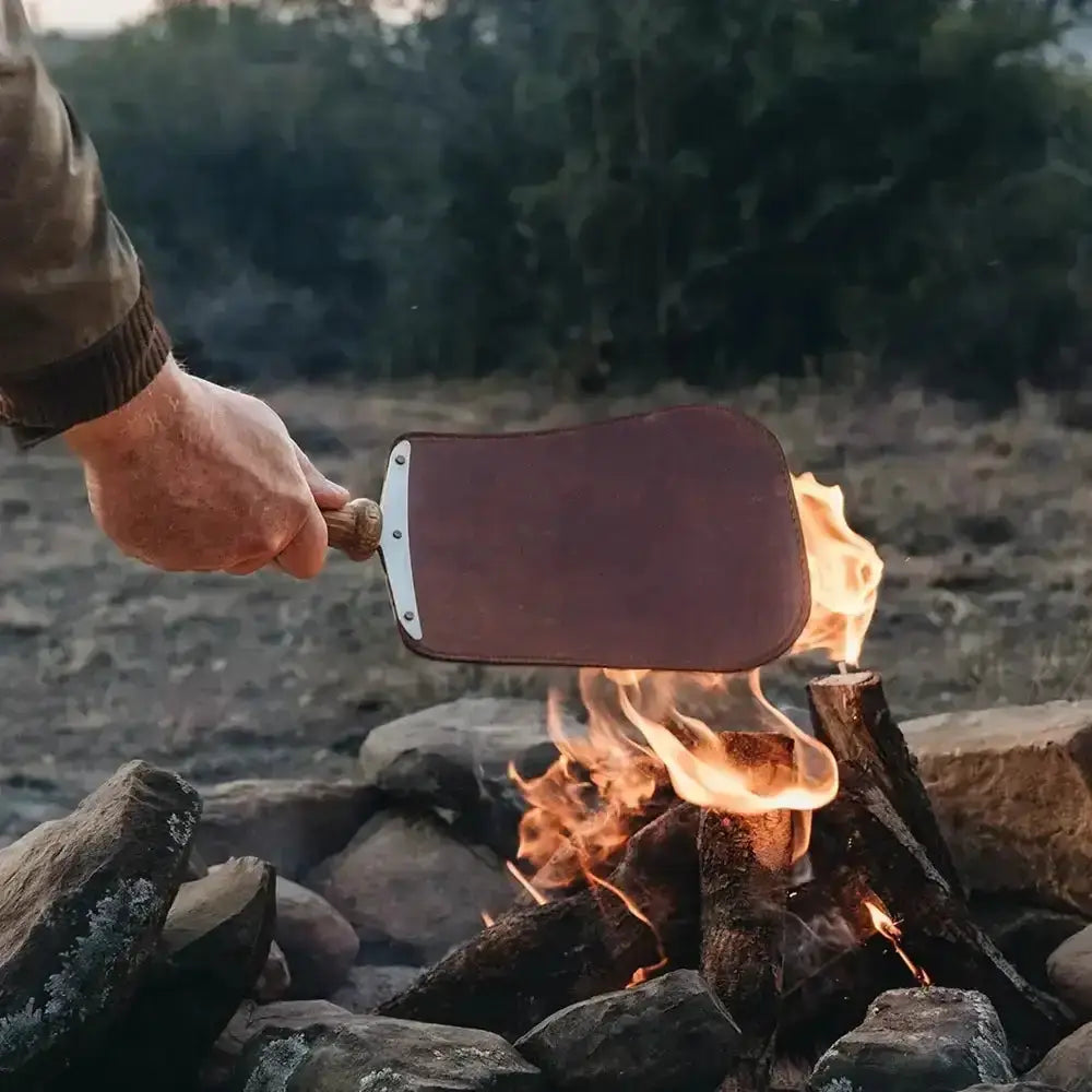 Leather handheld paddle with wooden handle used over outdoor campfire, Cookin Stores kitchenware