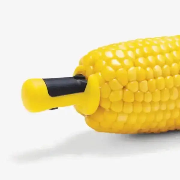 Dreamfarm Anchor Corn Lockorns set used on an ear of corn, yellow ergonomic corn holders.
