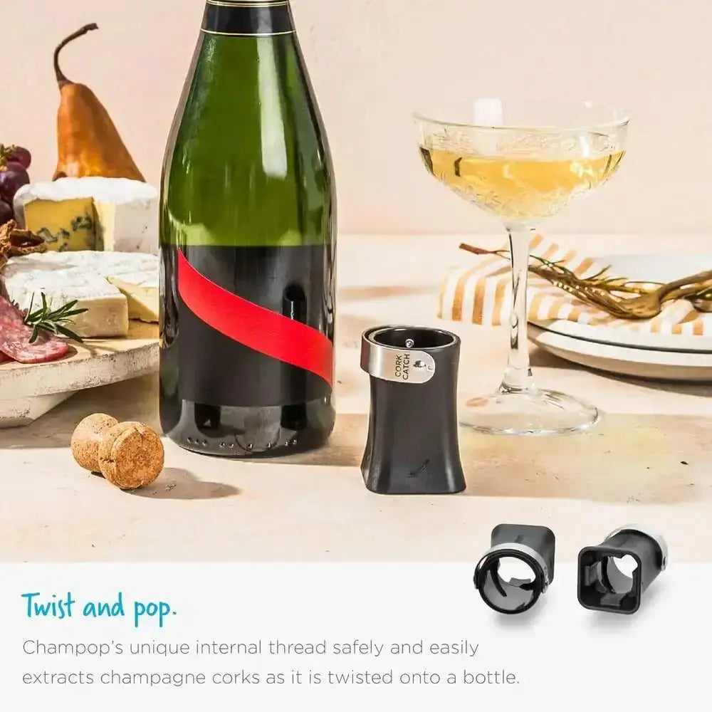 Champagne bottle with Dreamfarm Champop opener, glass, and cheese board on kitchen counter
