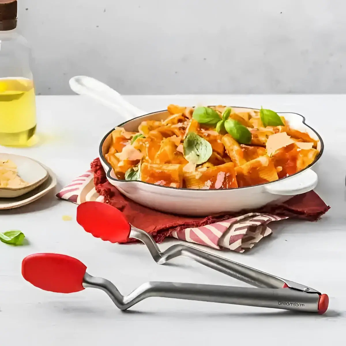 Dreamfarm Clongs charcoal black kitchen tongs on countertop beside pasta in a white pan at Cookin Stores