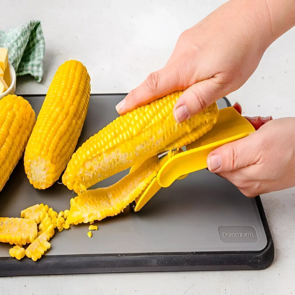 Dreamfarm corn peeler in use removing kernels from corn cob on kitchen board, Cookin Stores