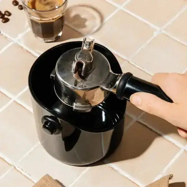 Dreamfarm Grindstein coffee knock box in black on kitchen counter with portafilter, Cookin Stores kitchenware