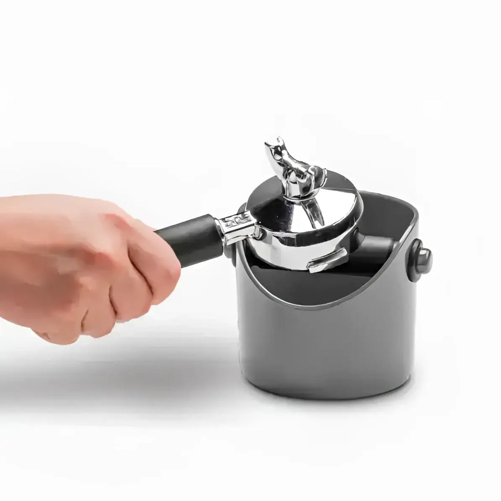 Hand using a metal ice cream scoop to take a scoop of ice cream from a container on a white background