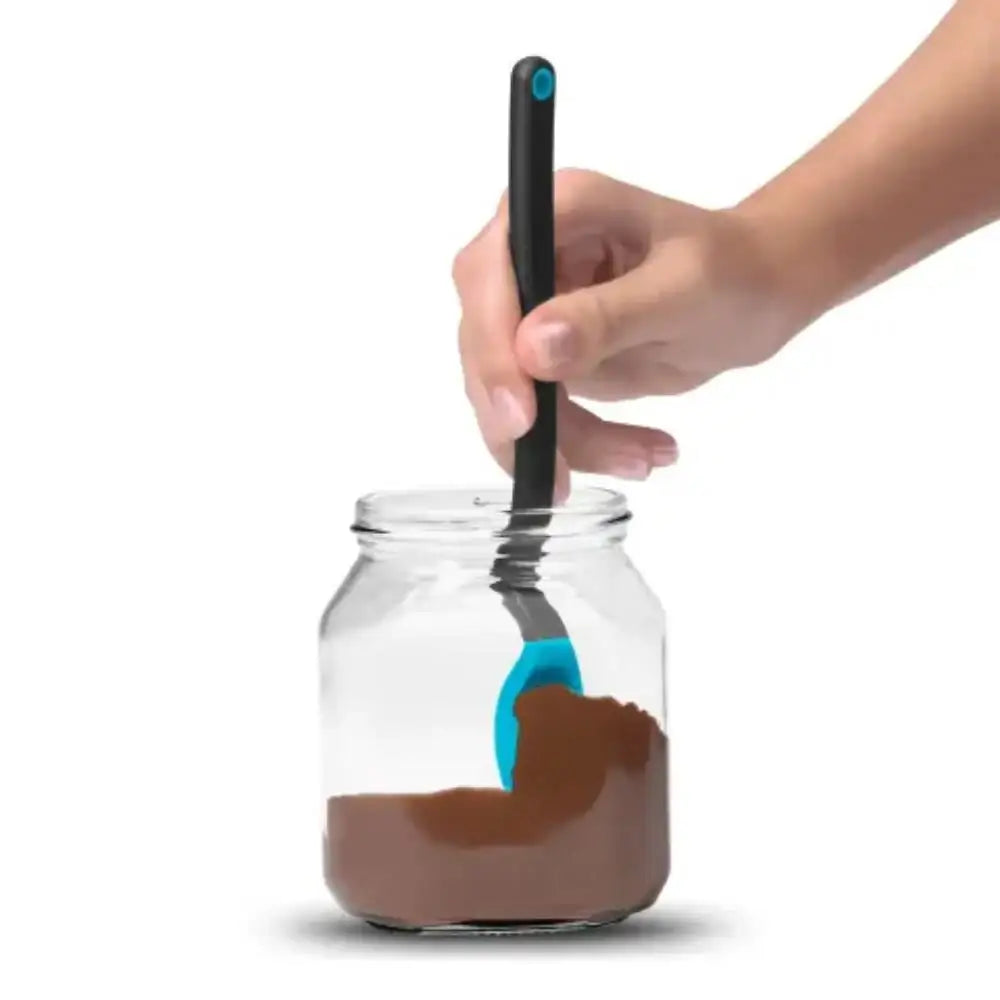 Hand using a spoon to scoop chocolate powder from a jar on a white background