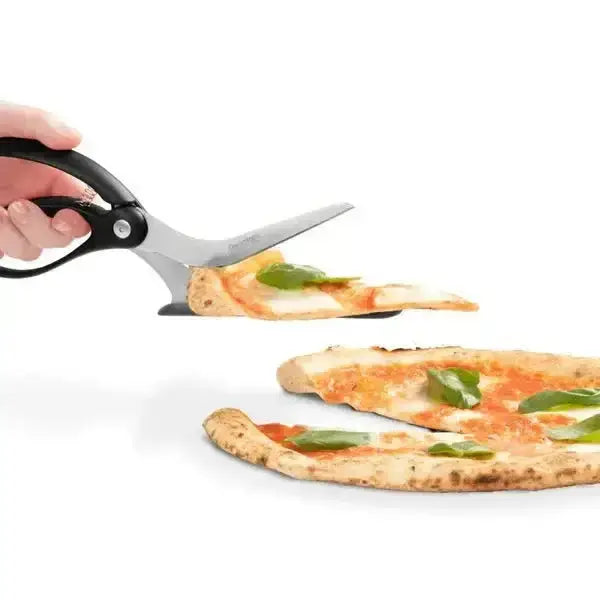 Black-handled pizza scissors slicing and serving a pizza slice with basil on a white background.