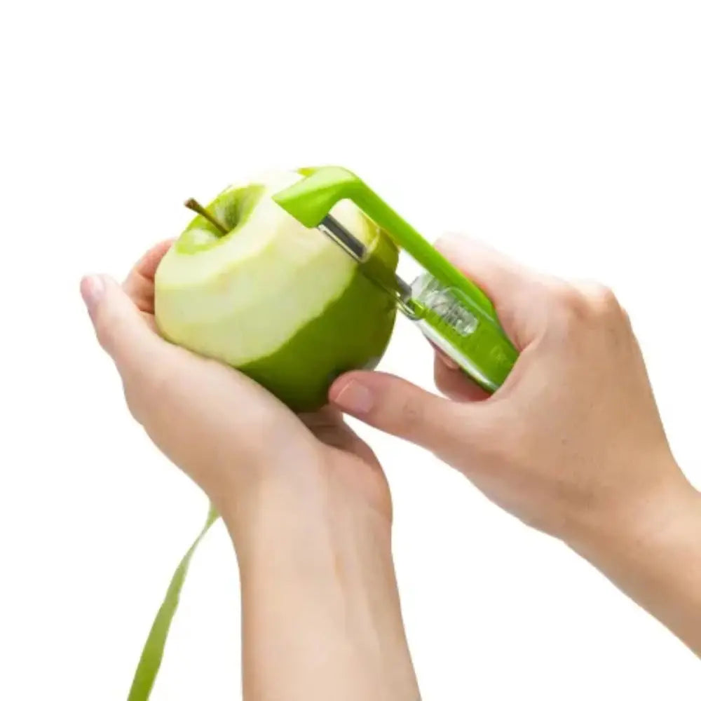 Person using a green apple peeler on a white background