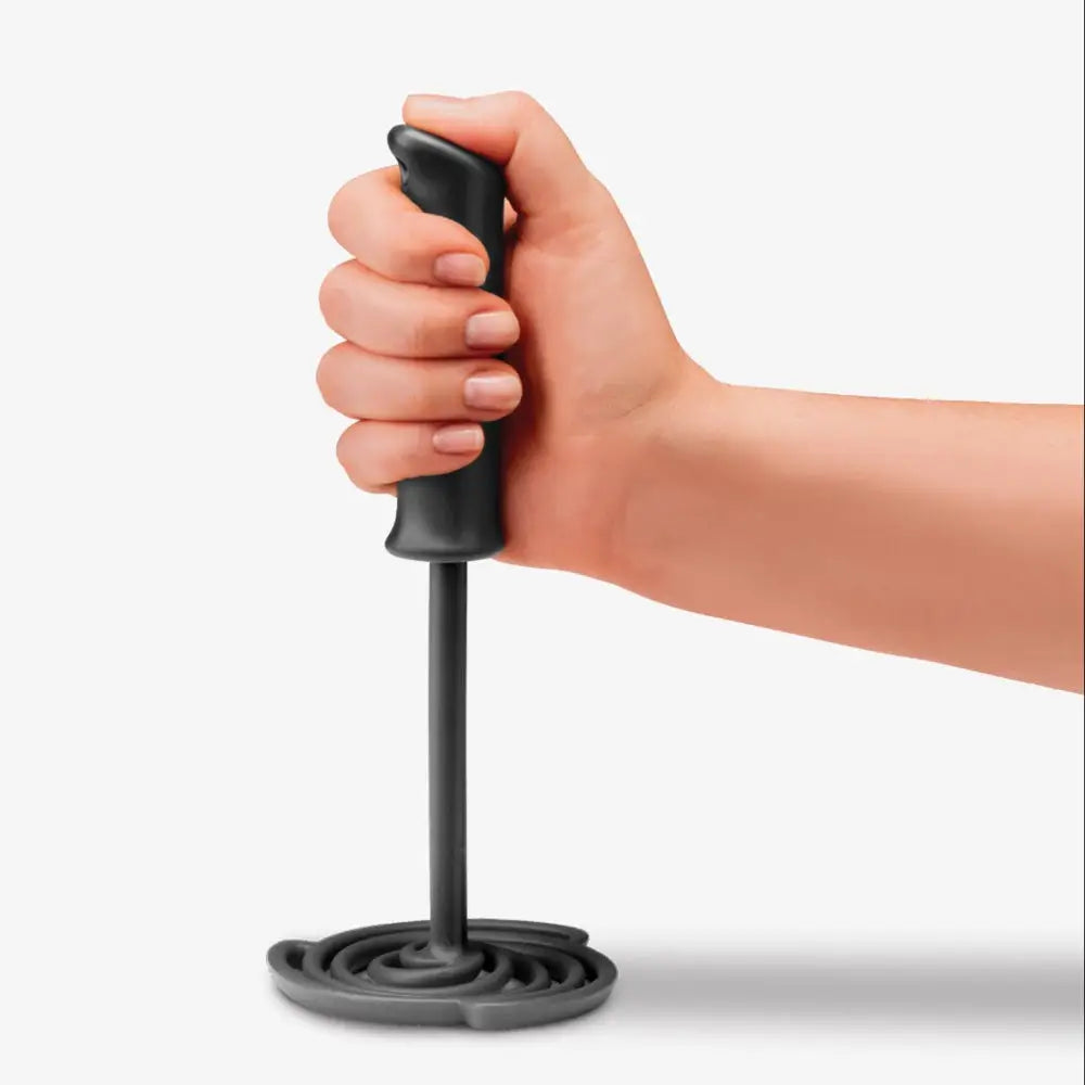 Hand holding a black masher against a white background